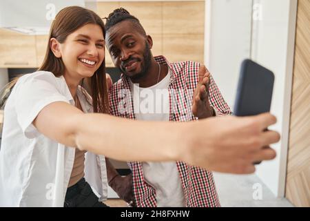 Joyful woman and man taking selfies indoors Stock Photo