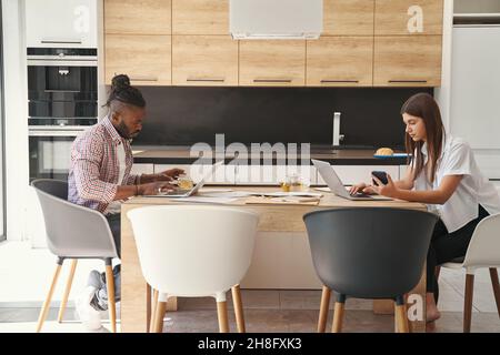 Two concentrated young freelancers sitting at laptops Stock Photo