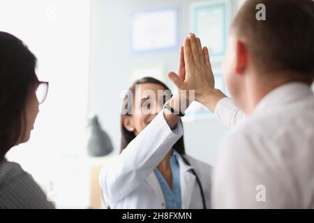 Colleagues give high five after successful agreement with partners Stock Photo