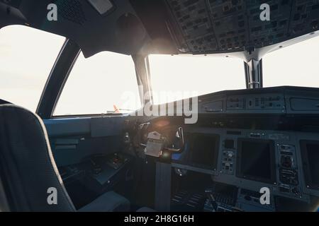 Empty airplane cockpit with sun shining through window Stock Photo