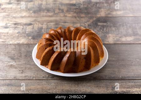 Traditional bundt cake piece with raisins on wooden table Stock Photo