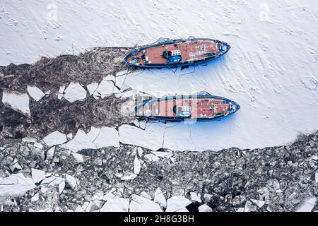 Two icebreakers on river breaking the ice in winter, Poland Stock Photo