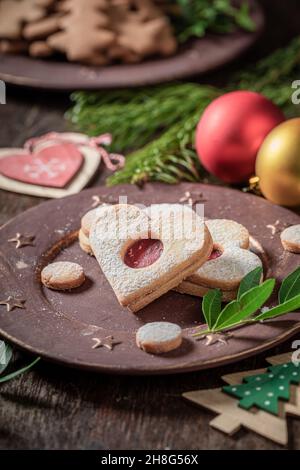 Homemade stained glass cookies with Christmas ornaments on wooden table Stock Photo