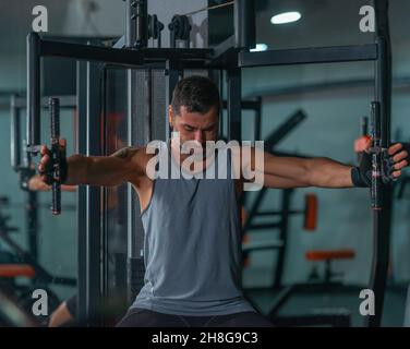Mature trainer athlete working out chest muscles doing strength training exercises on gym benchpress equipment. Stock Photo