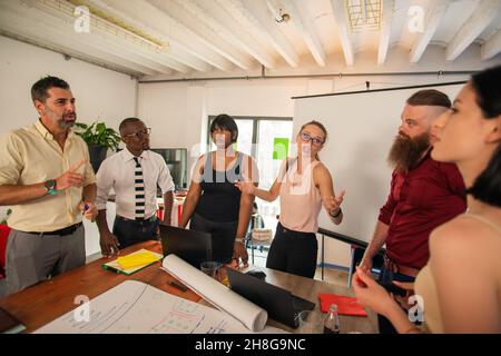 Group of multi racial co workers are discussing the plans for the new project Stock Photo
