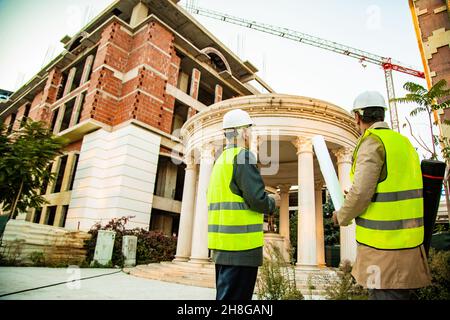 Two construction workers are looking at the construction area Stock Photo