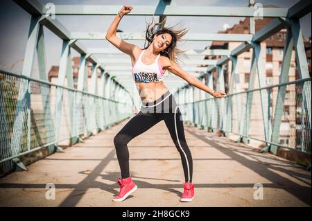 Zumba dance fitness instructor doing sport aerobic exercises. Motivational coach. Outdoor training Stock Photo