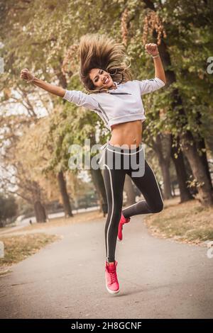 Zumba dance fitness instructor doing sport aerobic exercises. Motivational coach. Outdoor training Stock Photo