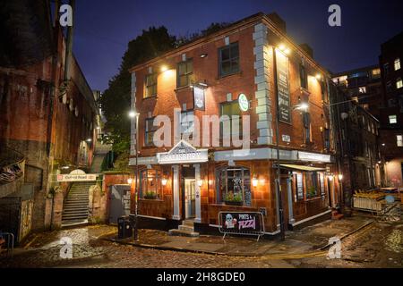 Manchester city centre cobbled street Wakefield St, with The Salisbury pub and a walkway to Oxford Road Railway Station Stock Photo