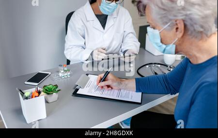 Woman filling in consent form for coronavirus vaccine Stock Photo