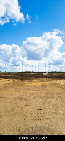 Blue sky with clouds on the background of a field and a dirt road. High quality Vertical photo Stock Photo