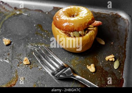 Homemade oven baked apples stuffed with pumpkin seeds and almond nuts in baking pan closeup Stock Photo