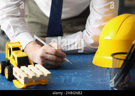 Male worker making corrections in construction planning with pencil Stock Photo