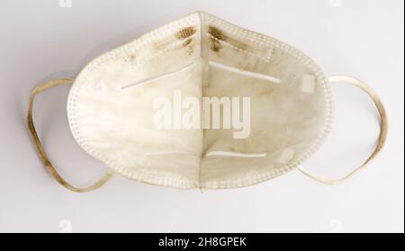 used dirty surgical protective face mask, isolated on white background, closeup view Stock Photo