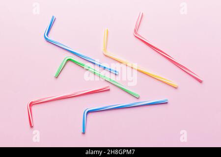 Drinking straws for party on Colored background. Top view of colorful plastic disposable straws for summer cocktails. different straws for juice with Stock Photo