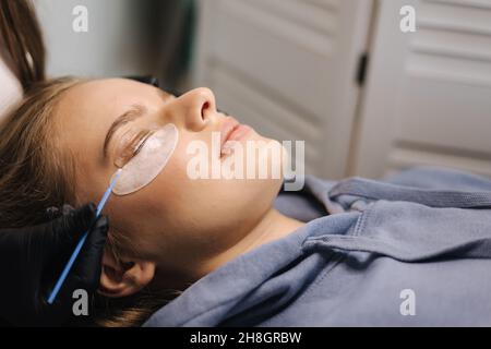 Attractive blond hair model in beauty studio having eyelash lamination. Modern useful procedure for lashes Stock Photo