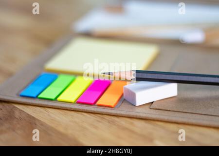 selective focus pencil for writing and multicolored square colorful sticky notes, rulers, and paper book on wood table concept equipment office and sc Stock Photo