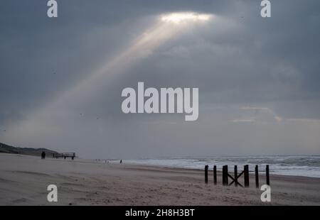 30 November 2021, Schleswig-Holstein, Westerland/Sylt: The sun shines through a hole in the clouds onto the beach of Westerland, where strong gusts of wind cause the water to pile up into high waves. Photo: Axel Heimken/dpa Stock Photo