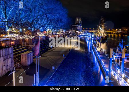 The medieval Christmas market Schlachte and the riverside promenade in Bremen, Germany are brightly illuminated Stock Photo