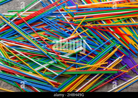many multi-colored plastic tubes for cocktail on Colored background, top view. Stock Photo
