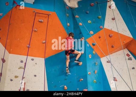 Boy at the climbing wall without a helmet, danger at the climbing wall Stock Photo