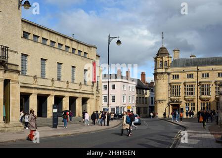 Shoppers on Broad Street Oxford with Indan Institute Building (1883) to left, now the Oxford Martin School part of Oxford University Oxford England Stock Photo