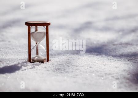 Hourglass in snow. Symbol of change daylight saving time to winter time Stock Photo