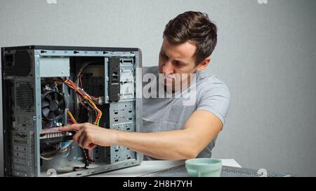 Young man opens a very dusty computer Stock Photo