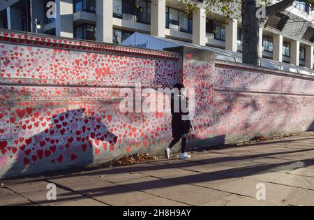 London, UK. 28th November 2021. People continue to visit and add names to the National Covid Memorial Wall outside St Thomas' Hospital. Over 150,000 red hearts have been painted by volunteers and members of the public, one for each life lost to Covid in the UK to date. Stock Photo