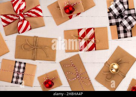 Top view flatlay of Christmas brown craft paper wrapped gift boxes on white wood background Stock Photo