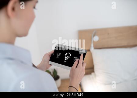 Female turning on light using a remote control Stock Photo
