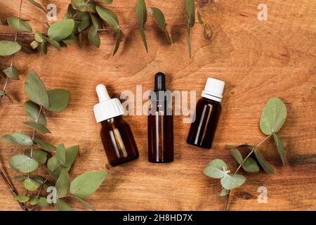 Brown bottles with droppers on a wooden background Stock Photo