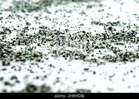 A background made out of strewn inside an activated carbon filter and water filter balls, isolated on a white background, selective focus in the cente Stock Photo