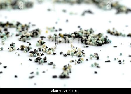 A background made out of strewn inside an activated carbon filter and water filter balls, isolated on a white background, selective focus in the cente Stock Photo