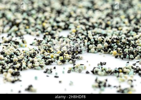 A background made out of strewn inside an activated carbon filter and water filter balls, isolated on a white background, selective focus in the cente Stock Photo