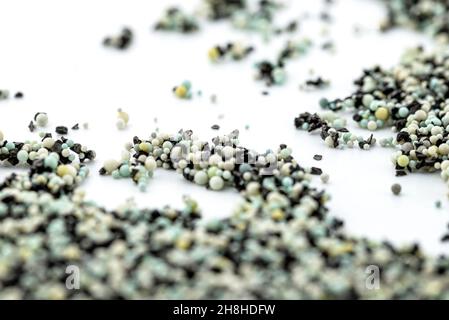 A background made out of strewn inside an activated carbon filter and water filter balls, isolated on a white background, selective focus in the cente Stock Photo