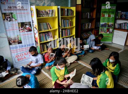 Bogor, Indonesia. 29th Nov, 2021. A group of children reading books at a community library at the foot of Mount Salak, Sukaluyu Village in Bogor, West Java, Indonesia, on November 29, 2021. (Photo by Adriana Adie/INA Photo Agency/Sipa USA) Credit: Sipa USA/Alamy Live News Stock Photo