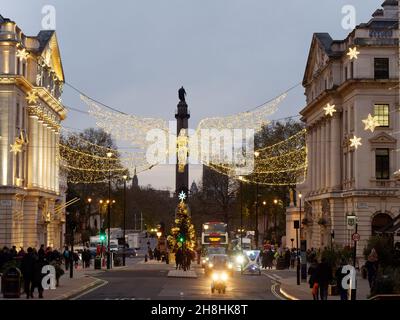 London, Greater London, England, November 28 2021: A Spirit of Christmas and Christmas Tree in front of the Duke of York Monument at Waterloo Place. Stock Photo