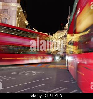 London, Greater London, England, November 28 2021: Spirit of Christmas festive light display on Regent Street St James as Buses pass by in Piccadilly Stock Photo