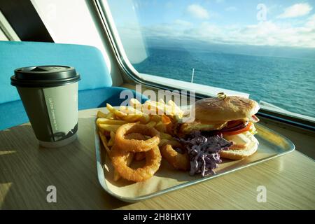 chicken burger onion rings coleslaw and fries meal on a ferry crossing the irish sea Stock Photo