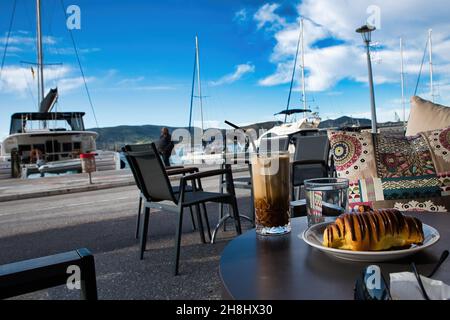coffee and chocolate croissants, enjoyment in the port of Volos, Greece Stock Photo