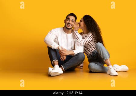 Sharing Secrets. Cheerful Young Woman Whispering To Her Boyfriend's Ear