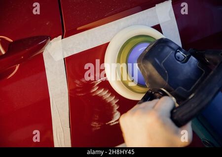 Master mechanic removal of dents defects auto repairman grinding automobile car body. Stock Photo