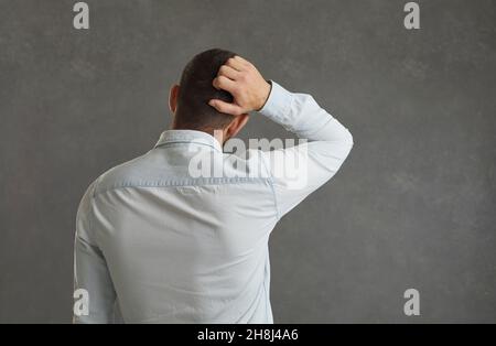 Back view of a pensive man scratching his head Stock Photo