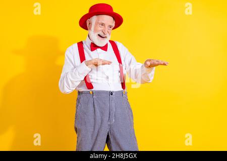 Photo of gentleman old man dance wear red cap tie shirt suspenders trouseres isolated on yellow background Stock Photo