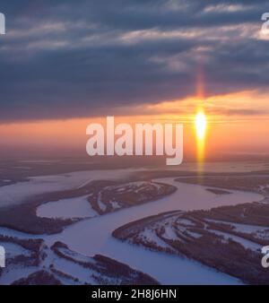 Air photo of amazing sunset above forest river during winter calm evening before Christmas Stock Photo