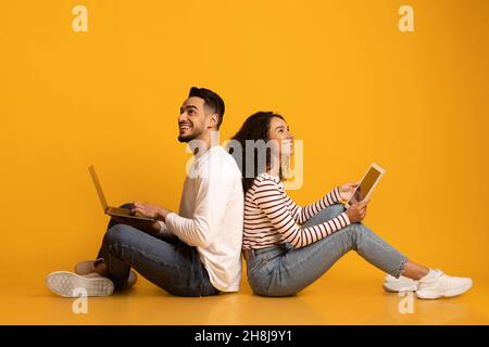 Online Entertainment. Happy Middle Eastern Couple With Laptop And Digital Tablet Stock Photo