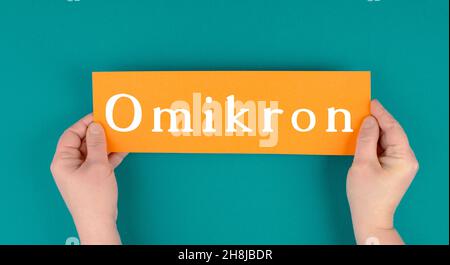 The german word for omicron is standing on a paper, new covid-19 variant from south africa, pandemic Stock Photo