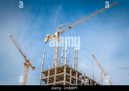New highrise houses and hoisting tower cranes Stock Photo