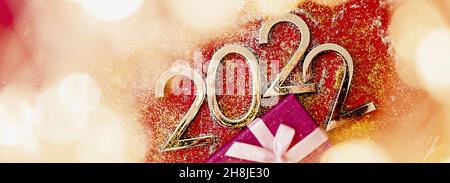 2022 New Year and Christmas celebration. Composition with numbers, gift box and blurry lights Stock Photo